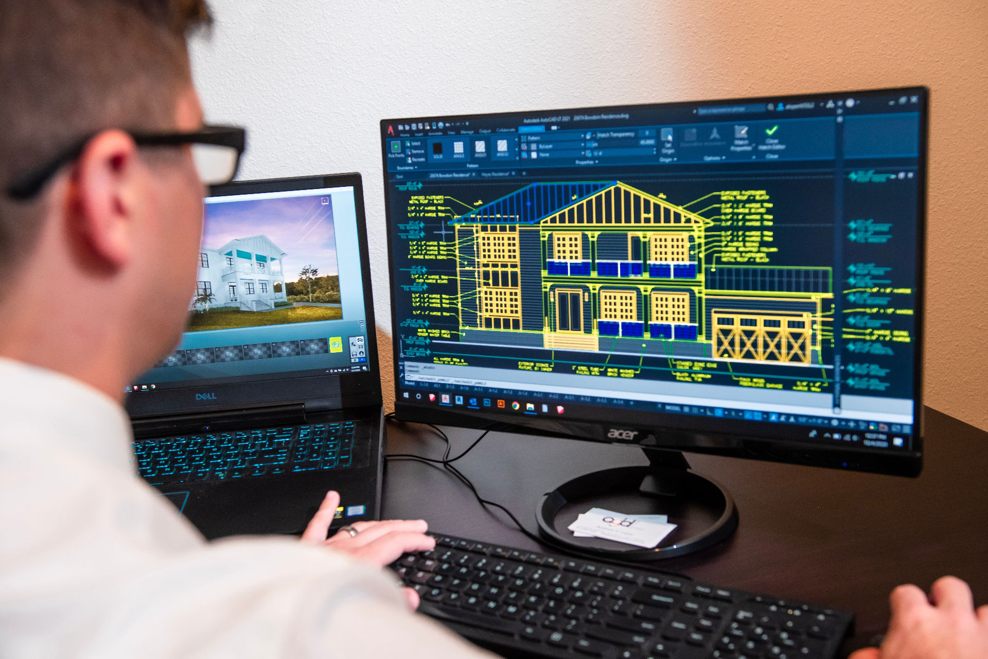 Architect reviewing a CAD elevation drawing alongside a 3D render